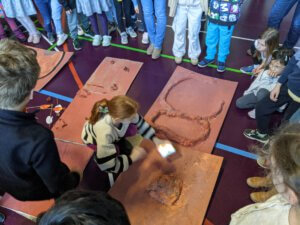 Enfants qui montrent leurs robots sur une piste fabriquée en papier brun