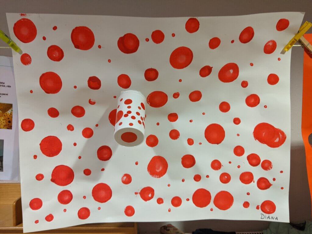 Œuvre de maternelle : pois rouges sur fond blanc