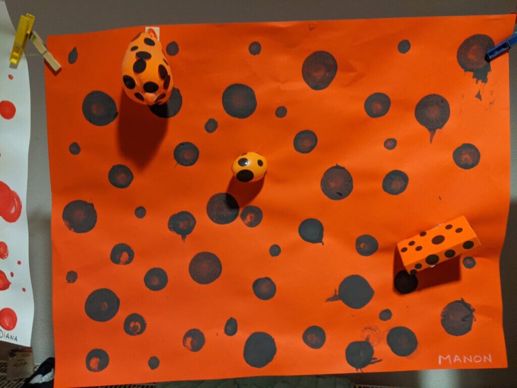 Oeuvre de maternelle orange et points noirs
